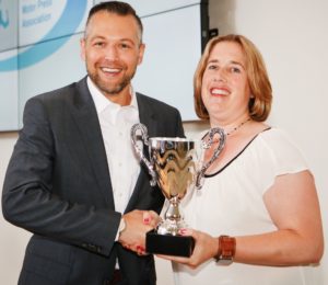 Corey Proffitt, East Coast Communications Manager for Toyota Motor North America accepts the Yankee Technology Cup from Vice President of NEMPA, Nicole Waklin.