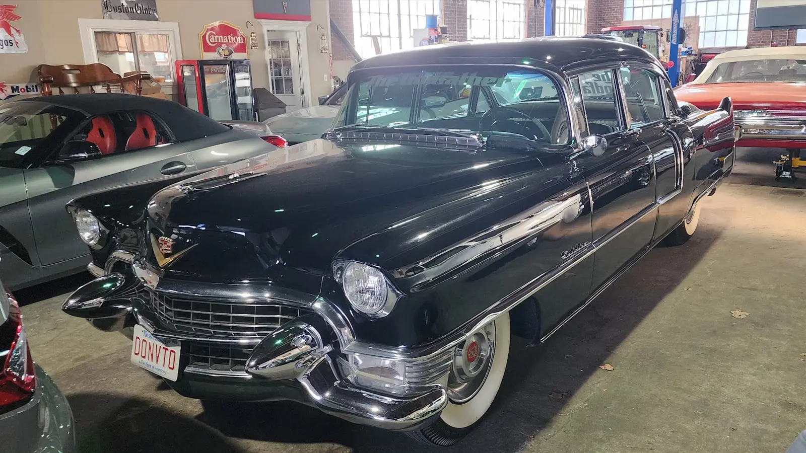 The black 1955 Cadillac Fleetwood from The Godfather on display in the Automotion museum collection, with a Massachusetts DONVTO license plate.